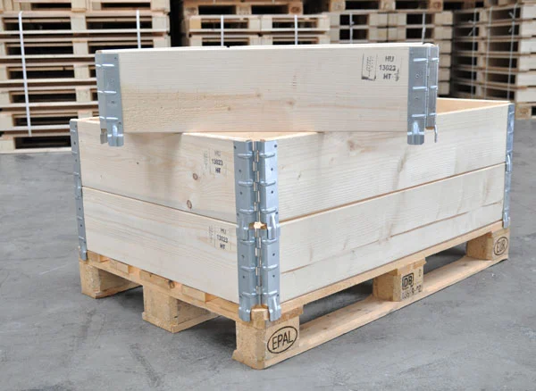 Stacked wooden pallet collars with metal hinges on a Euro pallet